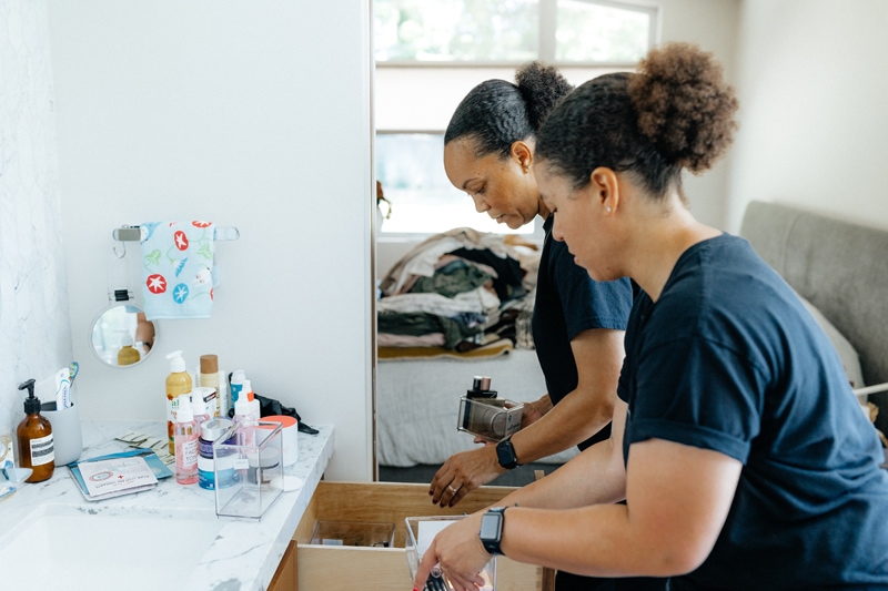 Professional Organizers, two women work within a home sorting and organizing